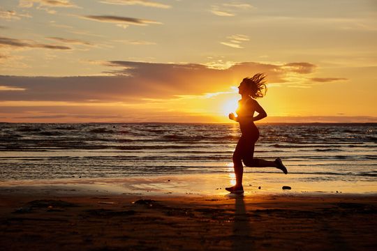 Mujer corriendo por la playa